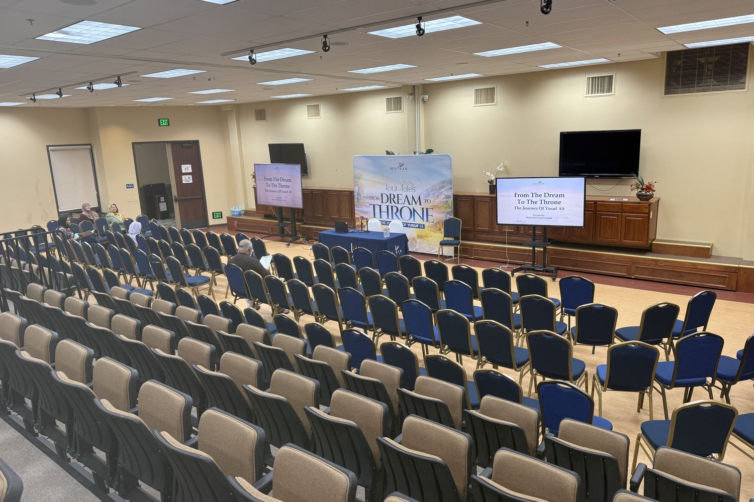The SALAM auditorium set in rows facing screens for a program