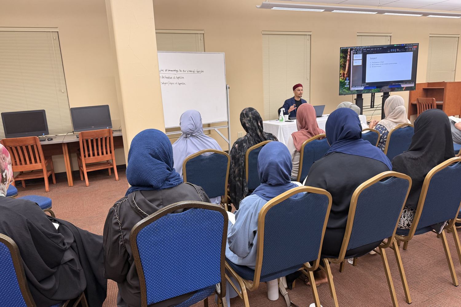 A meeting in the SALAM library with a screen and whiteboard