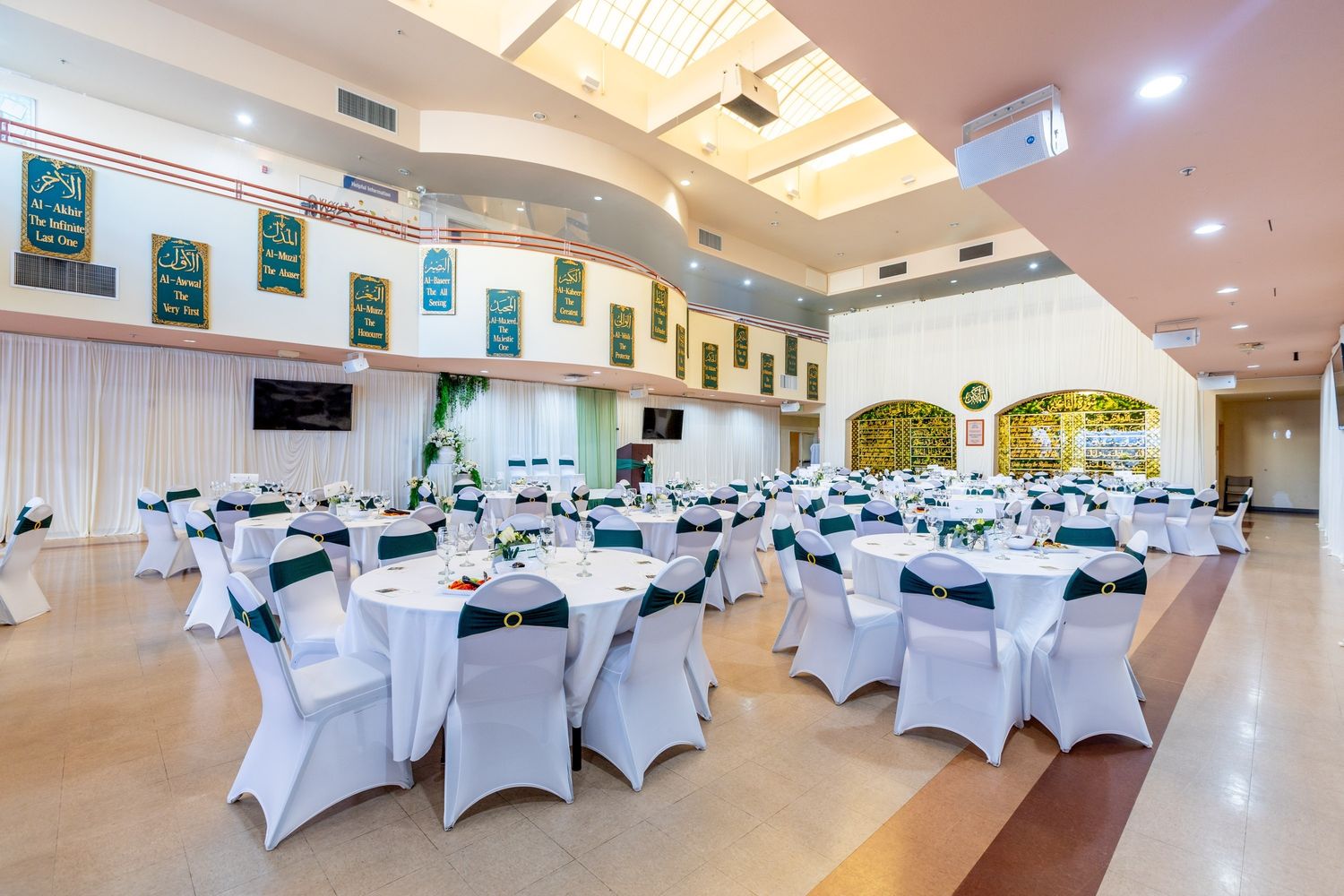 The SALAM Main Hall set with round tables and white chair covers for a dinner